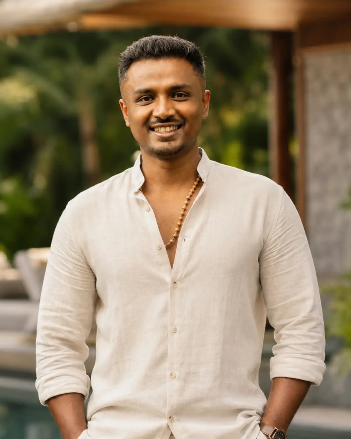 Abhiraam Gautham, standing outdoors in a cream linen shirt, looking towards the camera.