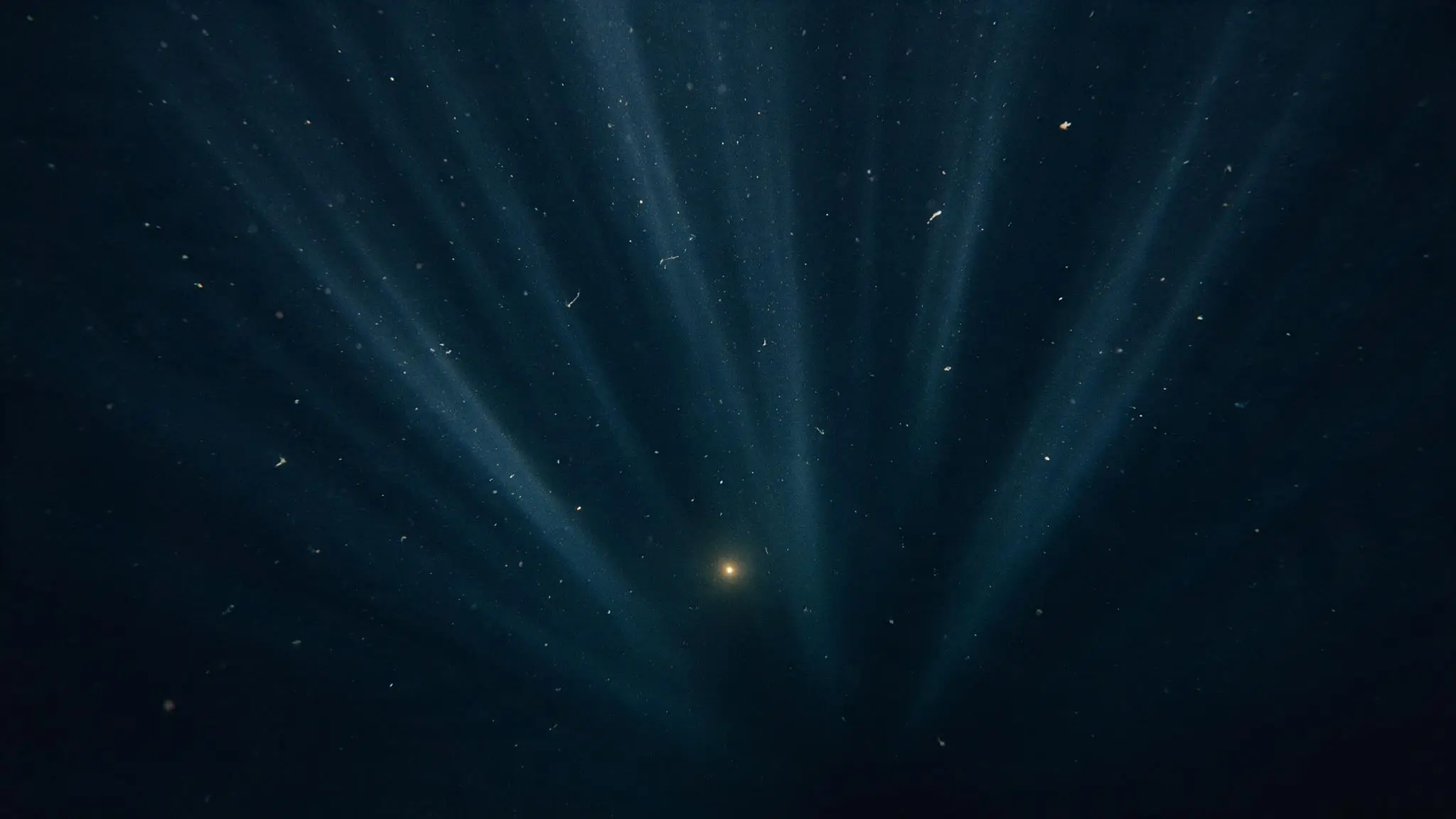 Shafts of cold light descending into deep, dark water.